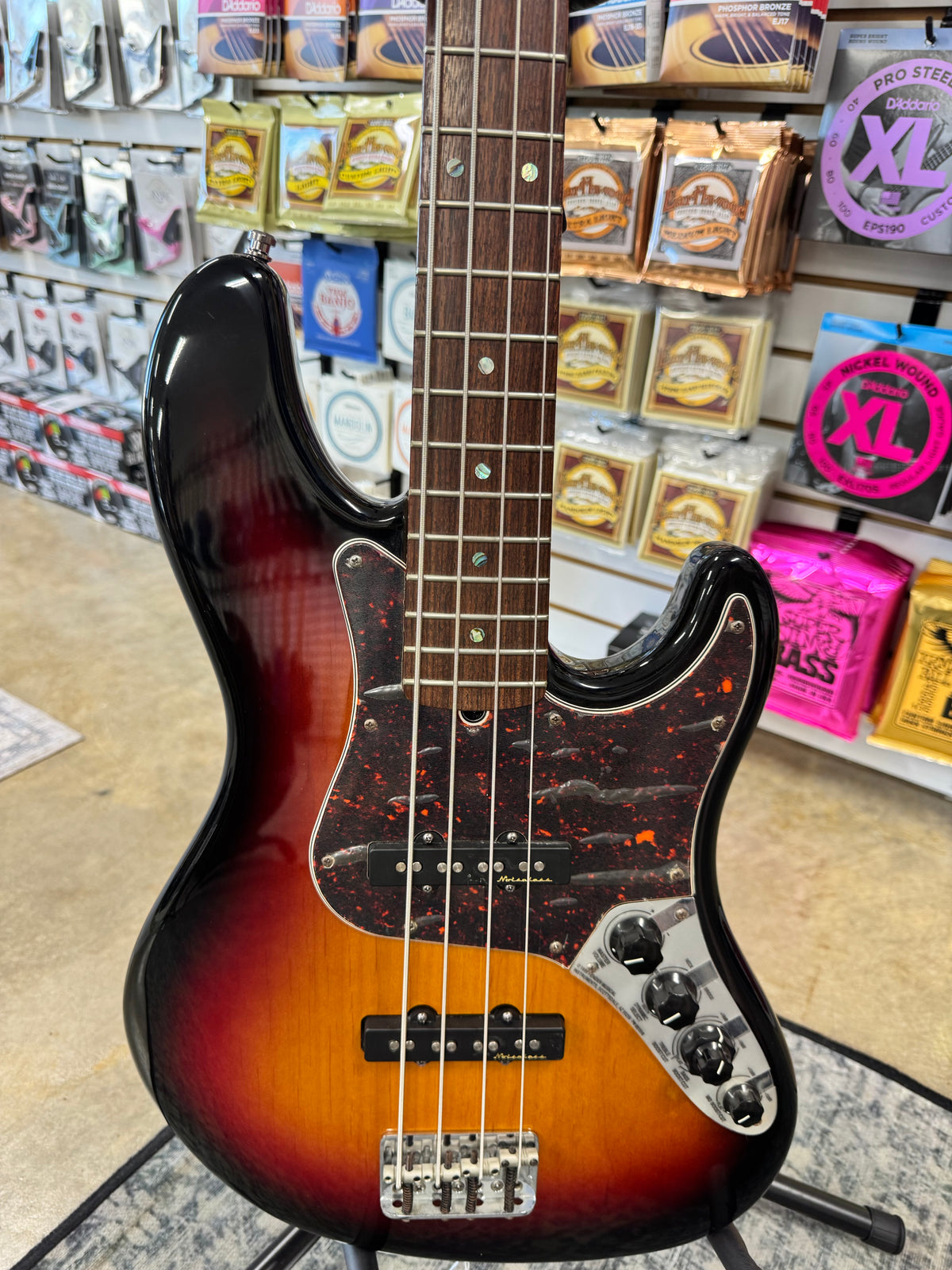 Used 2003 Fender American Deluxe Jazz Bass, 3-Color Sunburst - body close-up with tortoiseshell pickguard and pickups